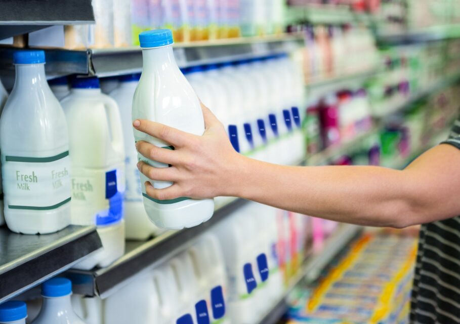 Womans,Hand,Holding,Milk,Bottle,In,Supermarket
