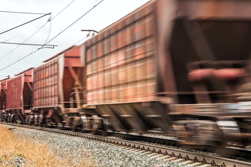 a freight train with bulk wagons rushing along the railway.