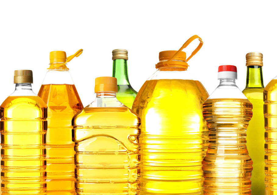 Different bottles with cooking oil on white background